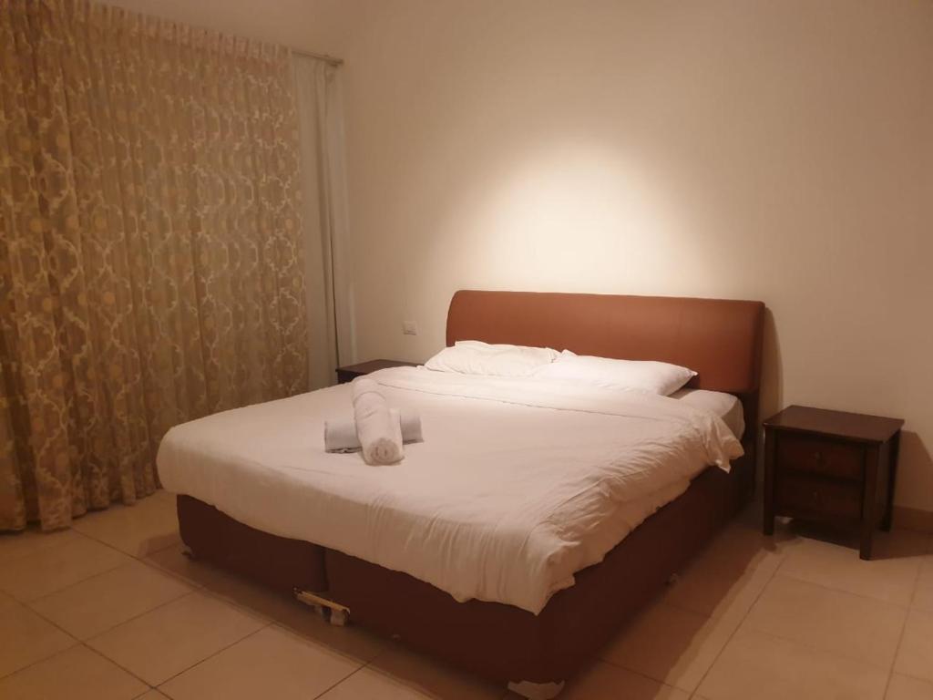 Flat Luxury 2 bed rooms apartment talabay aqaba في العقبة: سرير عليه منشفتين في غرفة النوم