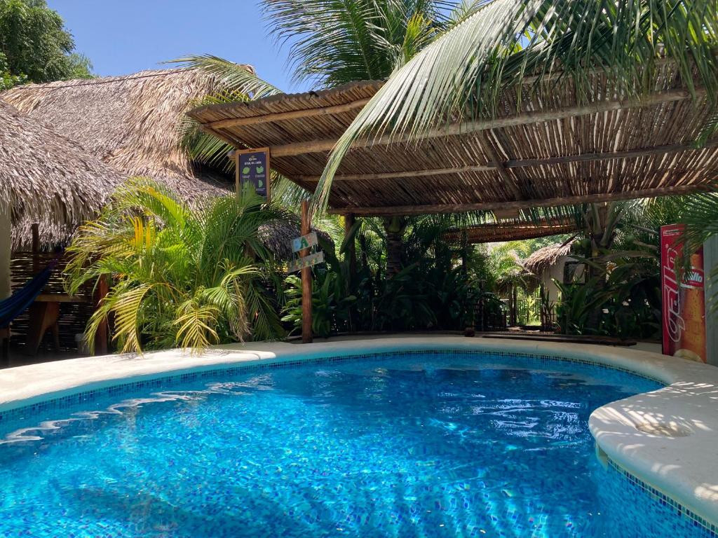 uma piscina com um guarda-sol e um resort em Sunrise El Paredón em El Paredón Buena Vista