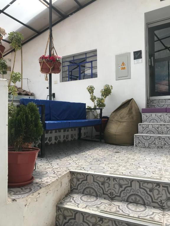 a patio with a blue bench and potted plants at Saqray Hostel in Cusco