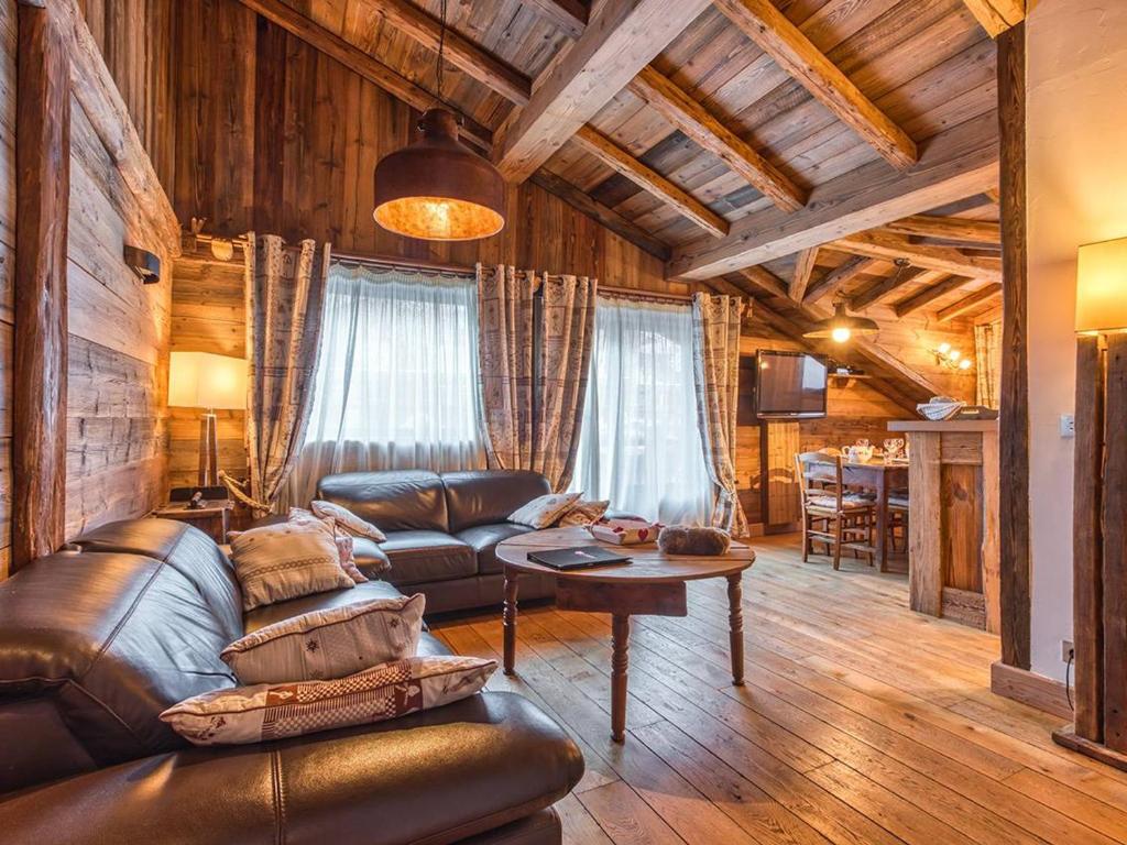 a living room with a leather couch and a table at Appartement de Charme à Courchevel 1850 - 4 pers, Centre, Proche des Pistes, Balcon et Hammam - FR-1-631-163 in Courchevel