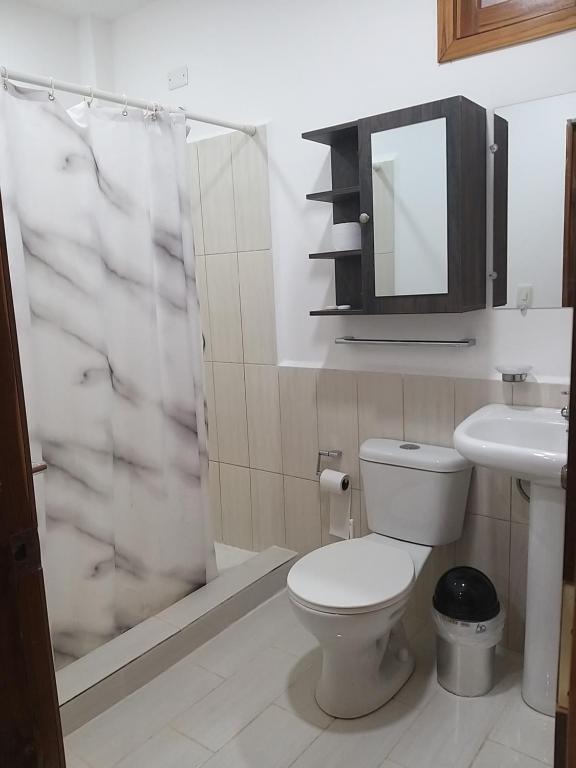 uma casa de banho com um WC, um lavatório e um chuveiro em Nueva Tierra em Las Tunas