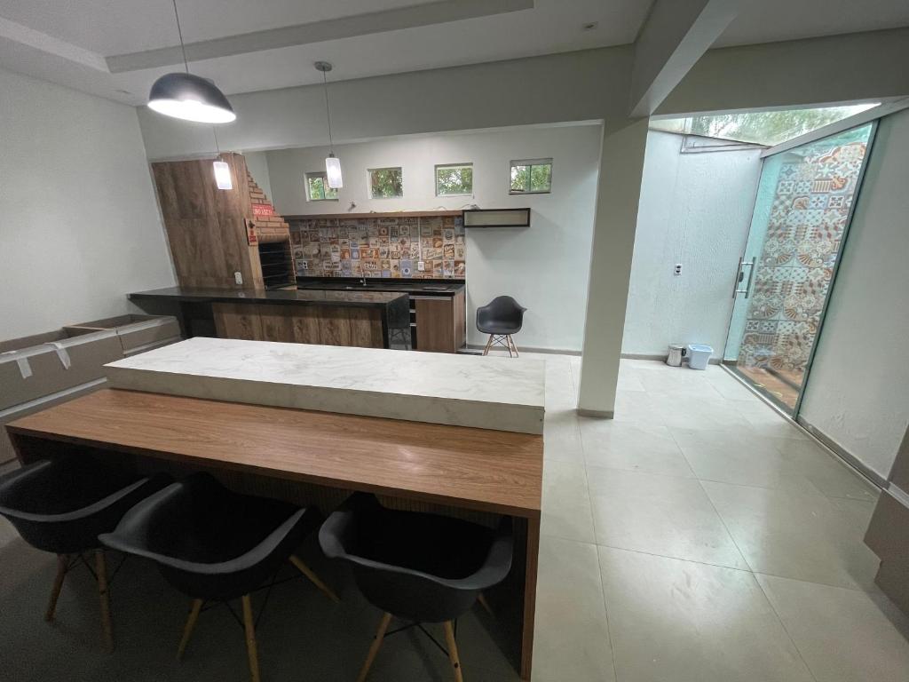 eine Küche mit einem großen Holztisch und Stühlen in der Unterkunft Casa aconchego Luís Eduardo Magalhães in Luis Eduardo Magalhaes