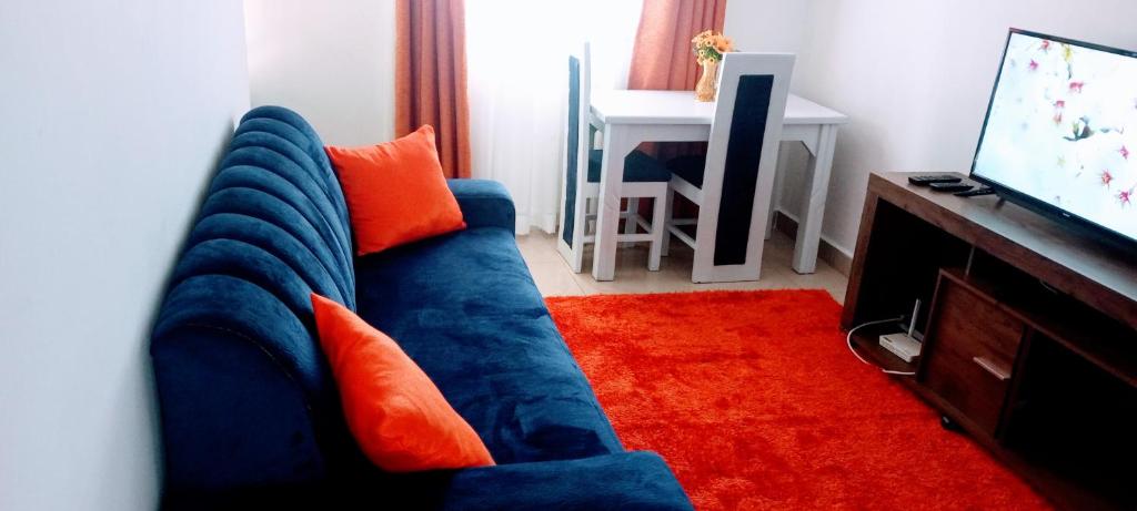 a blue couch with orange pillows in a living room at Comfort Inn in Kisumu