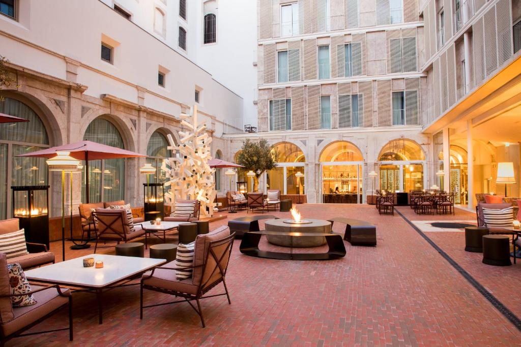 a courtyard with tables and chairs in a building at Convent Square Lisbon, Vignette Collection, an IHG Hotel in Lisbon