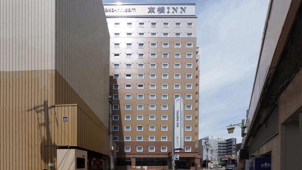 Un edificio alto con un cartel encima. en Toyoko Inn Himeji-eki Shinkansen Kita-guchi, en Himeji