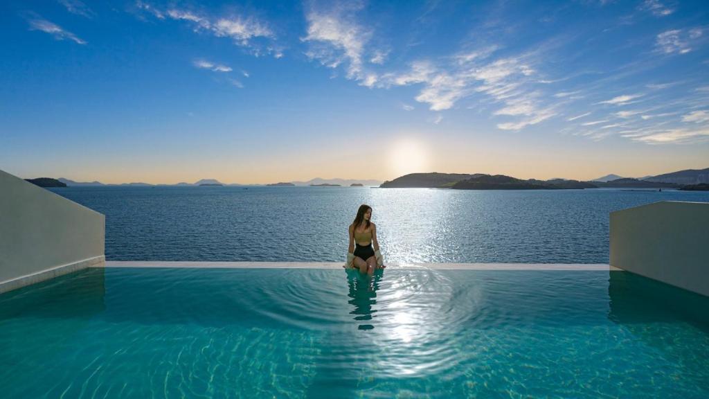 a woman in a swimming pool in the water at Stone Island Pool Villa in Yeosu