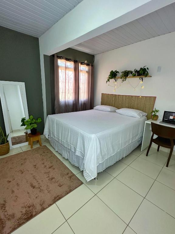 Hostel Native في بوا فيستا: غرفة نوم بسرير كبير وطاولة ومكتب