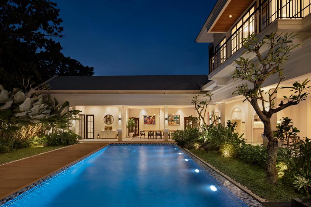 - une piscine dans l'arrière-cour d'une maison la nuit dans l'établissement Bincarung House Bogor, à Bogor