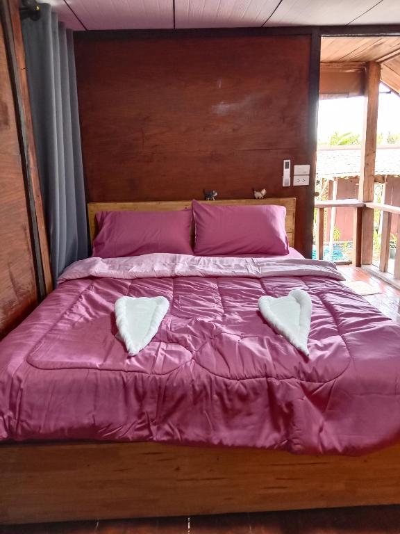 ein großes Bett mit zwei weißen Herzen darauf in der Unterkunft บ้านทุ่งโฮมสเตย์ in Ban Chai Khlong