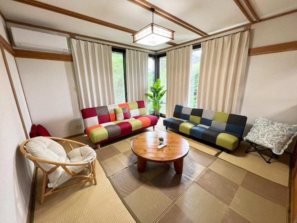ein Wohnzimmer mit 2 Sofas und einem Couchtisch in der Unterkunft シークレットベースゆふいん in Yufu