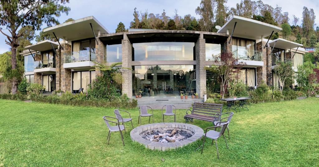 a house with a fire pit in the yard at Mountain Retreat Kodai in Kodaikānāl