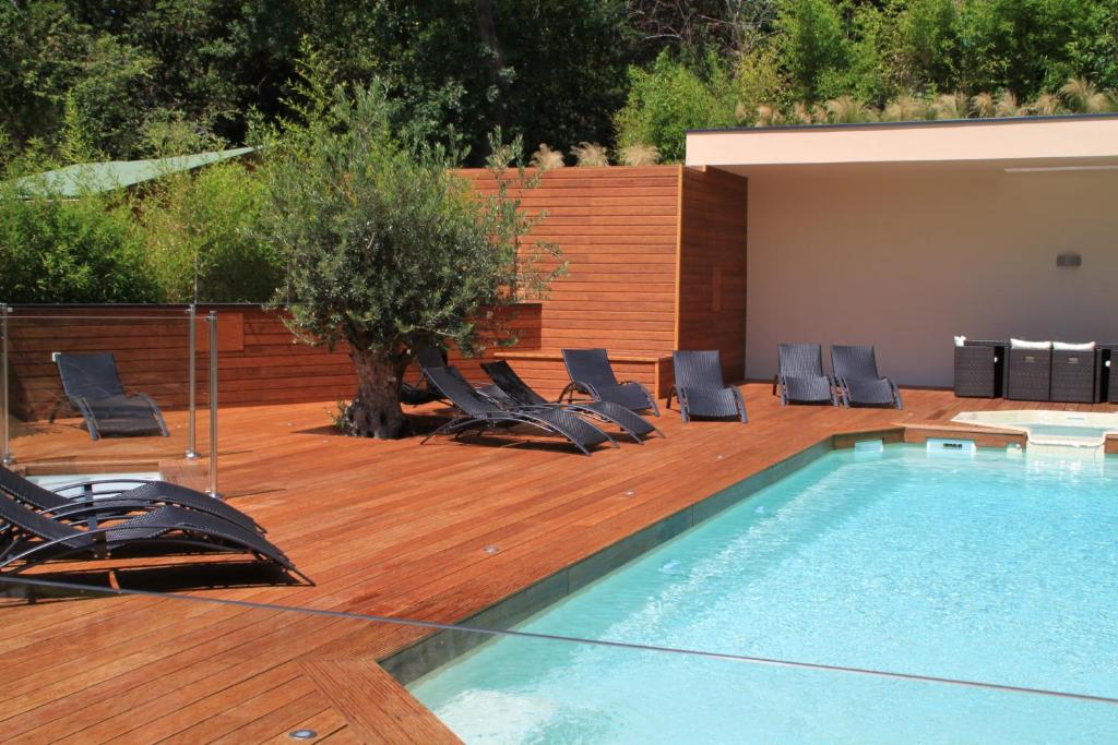 a pool with lounge chairs next to a wooden deck at Hotel du Parc in Arcachon