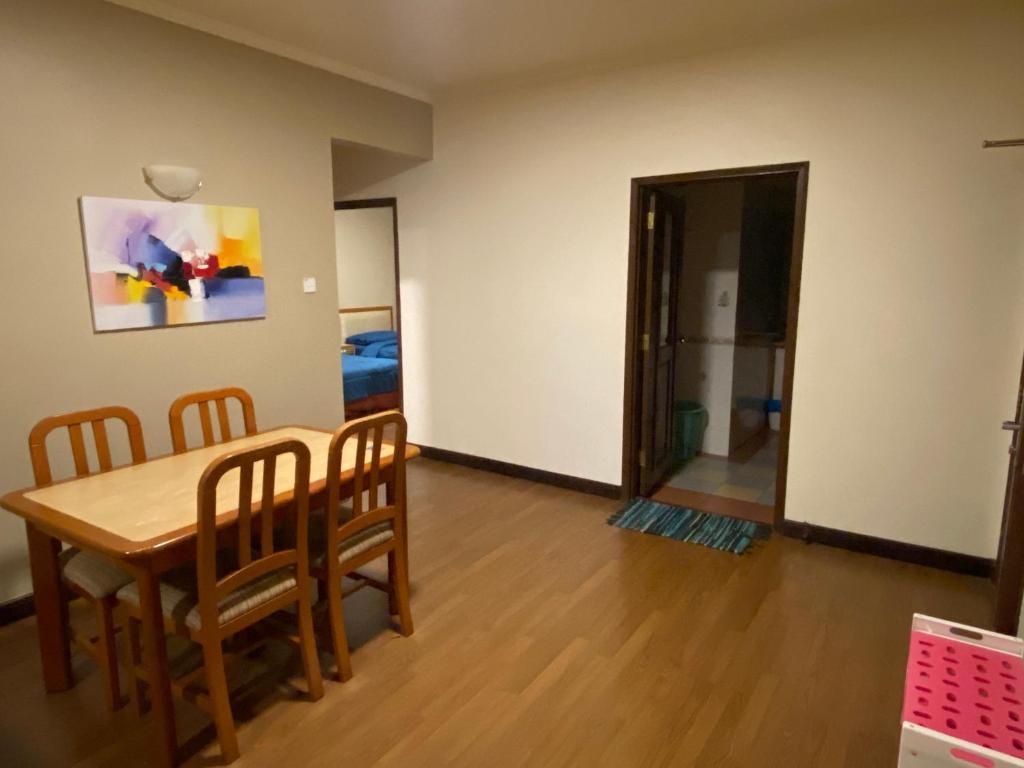 uma sala de jantar com uma mesa e cadeiras num quarto em COZY HOME COPTHONE RESORT em Brinchang