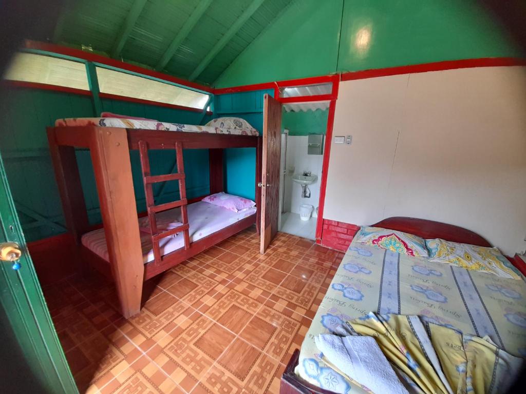 Playa LadrillerosにあるCabaña Playa Ladrillerosの二段ベッド2台、バスルームが備わる小さな客室です。