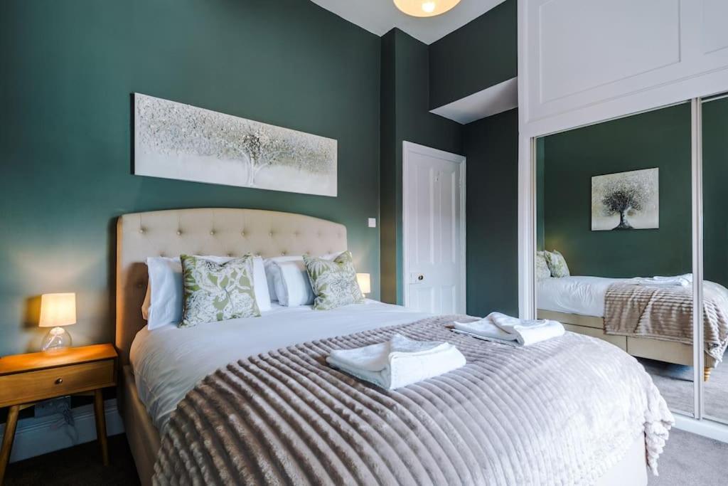 a bedroom with a large bed with green walls at 1B Victorian Retreat in Chester in Chester