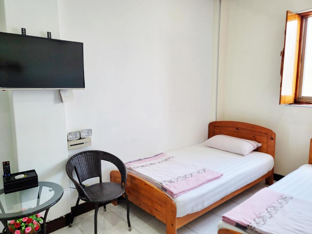 Camera piccola con letto, tavolo e TV di 芹壁溫馨海景民宿 a Beigan