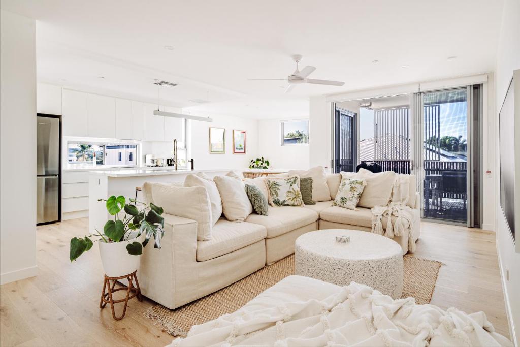 a white living room with a couch and a table at SILK - Lustrous Vacation Awaits 400m to the Beach in Coolum Beach