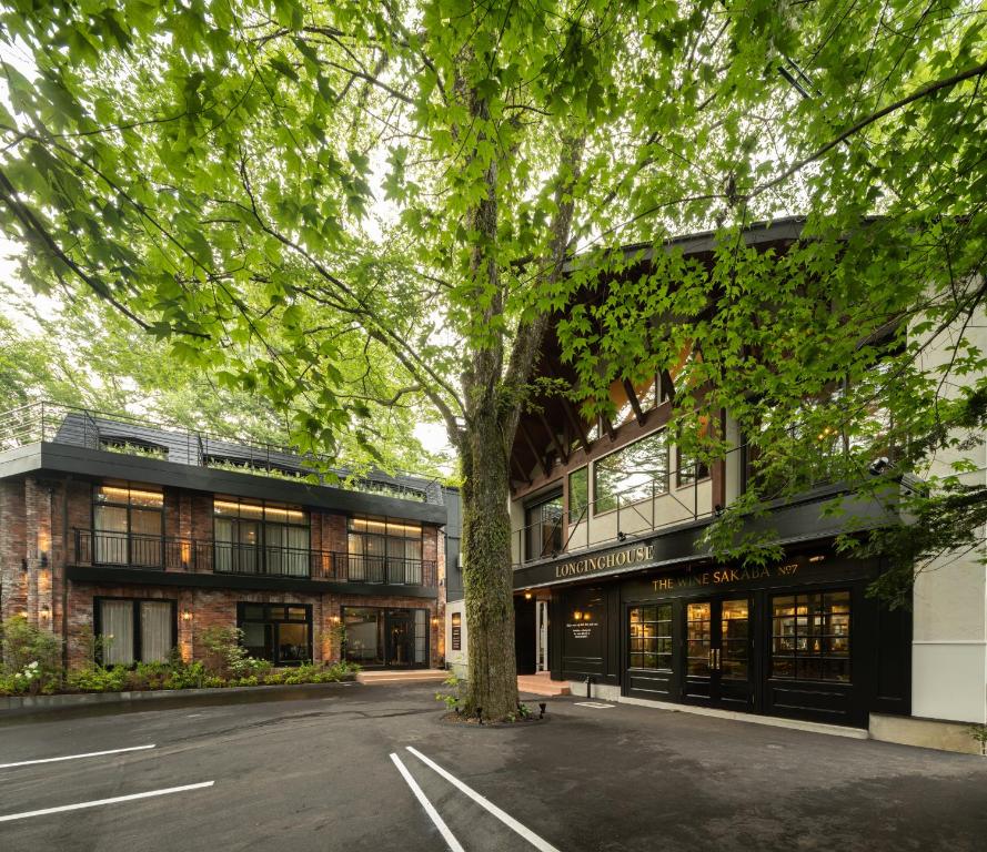 a building with a tree in front of it at LONGINGHOUSE Kyukaruizawa Suwanomori in Karuizawa