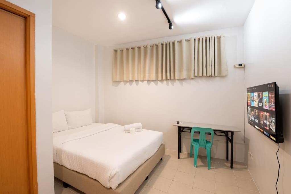 - une chambre avec un lit et un bureau avec une chaise dans l'établissement JP Santiago Studio Makati J303, à Manille
