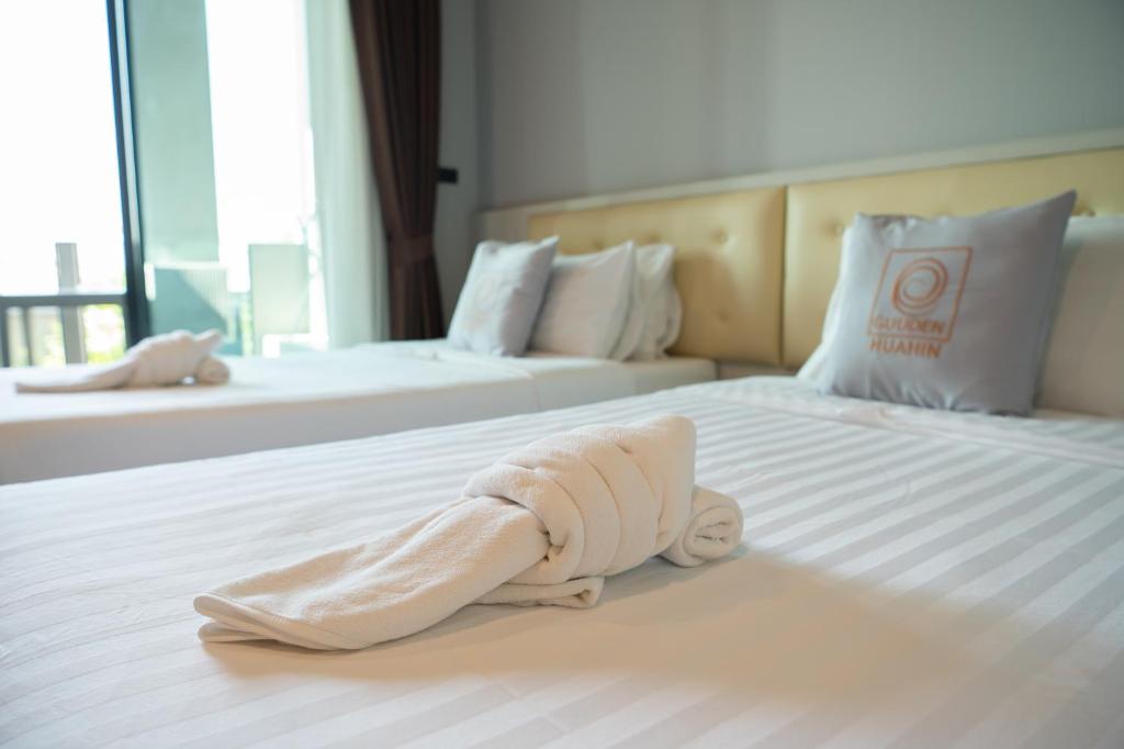 Postel nebo postele na pokoji v ubytování Guuden Huahin Hotel
