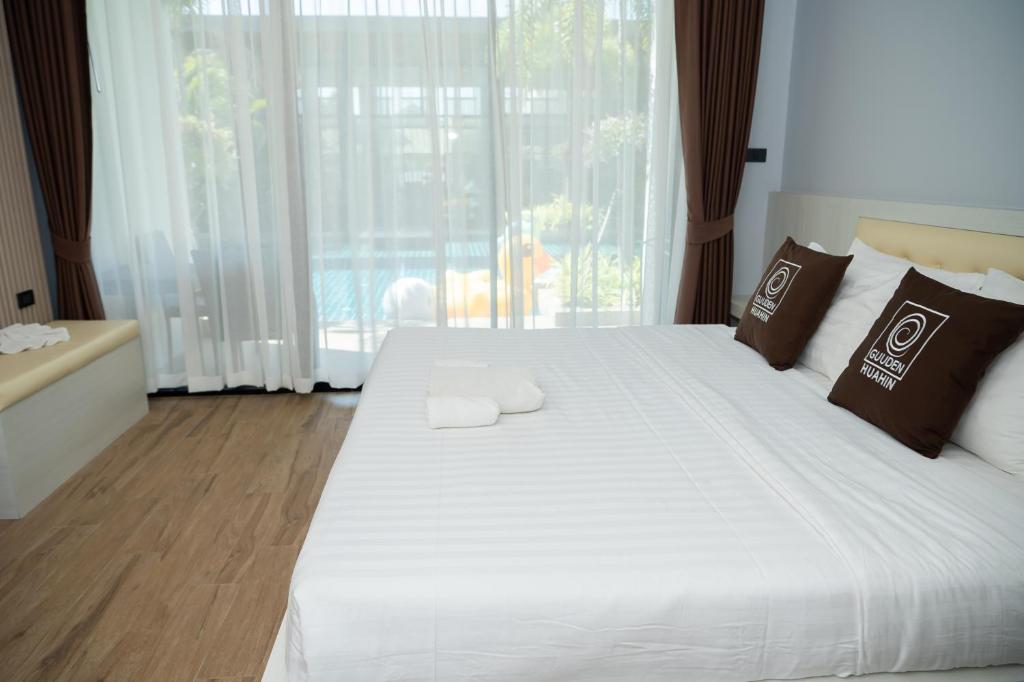 Postel nebo postele na pokoji v ubytování Guuden Huahin Hotel