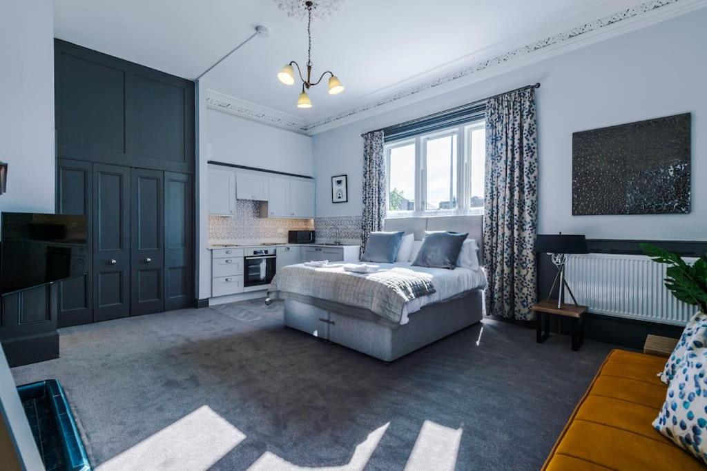 a large bedroom with a bed and a kitchen at Supersized Studio in Chester in Chester