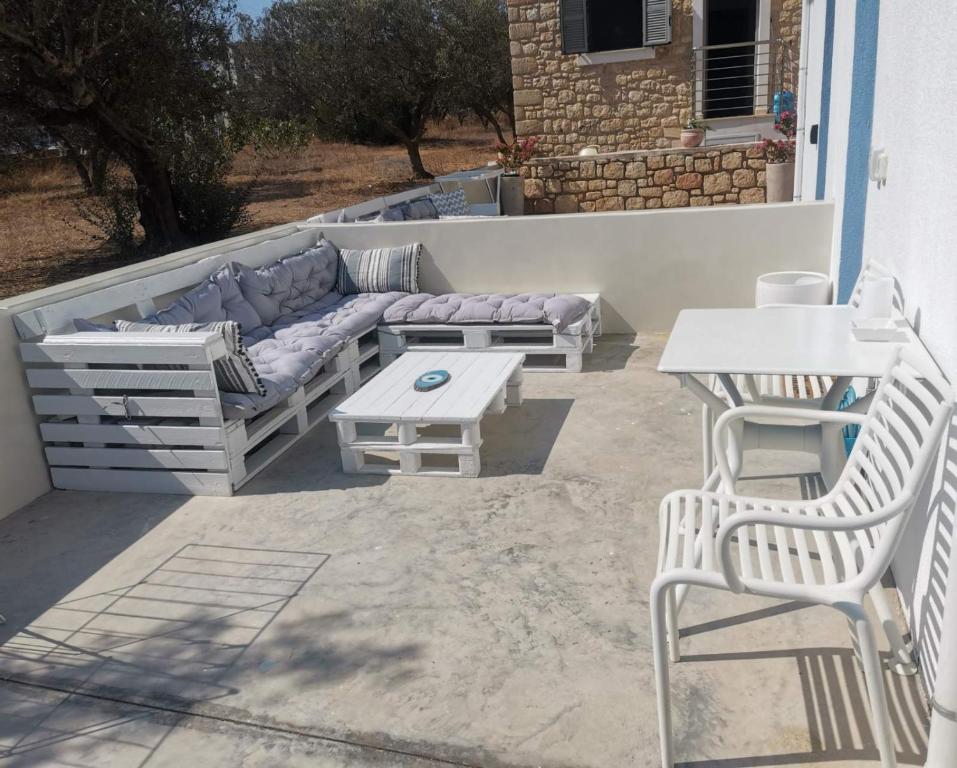 a patio with a couch and a table and chairs at Sea and Sand in Elafonisos