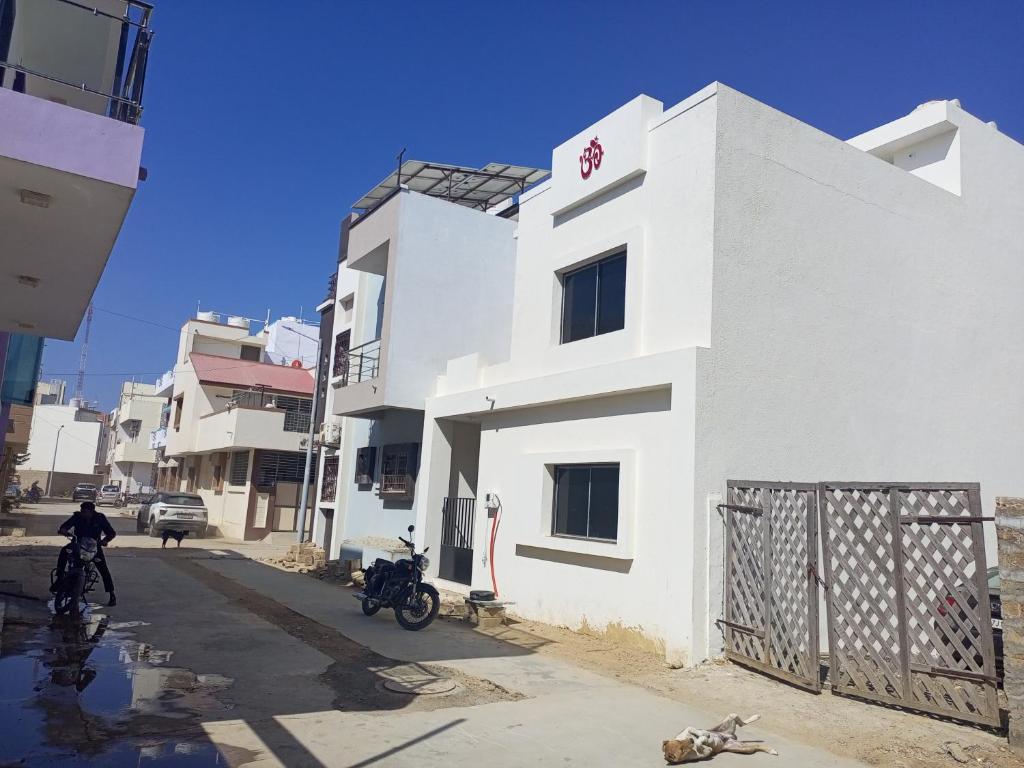 a white building with two motorcycles parked on a street at DWARKA BUNGALOW Only Family Full Bungalow in Dwarka