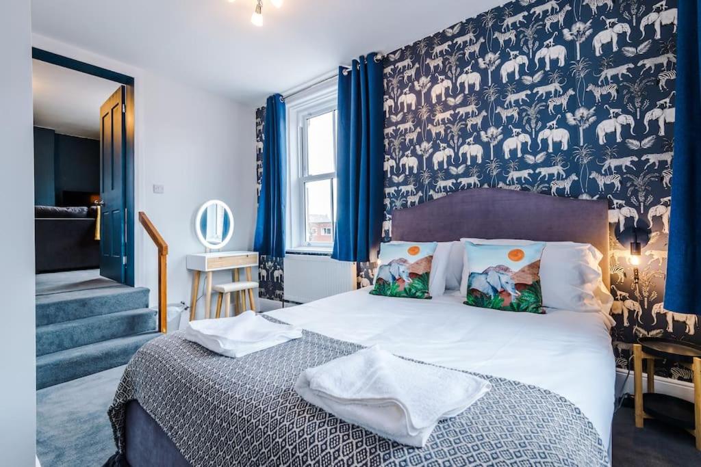 een slaapkamer met een bed en een muur met blauwe gordijnen bij ZooBlu: Chester 1-Bed in Chester