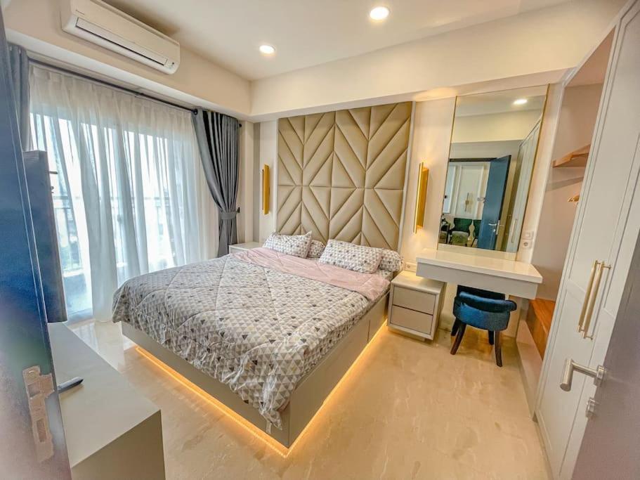sypialnia z dużym łóżkiem i lustrem w obiekcie Brand new 2BR Empire Tower - Podomoro City w mieście Medan