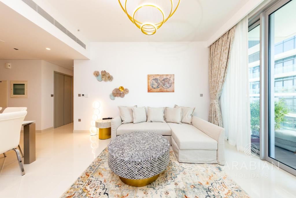 een woonkamer met een bank en een tafel bij Brand New 2BR Apt with Palm Views and Private Beach - High Floor in Dubai