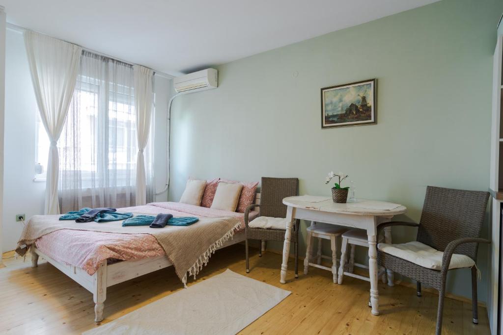 a bedroom with a bed and a table and chairs at Copenhagen adorable and cosy Apt in calm district in Sofia