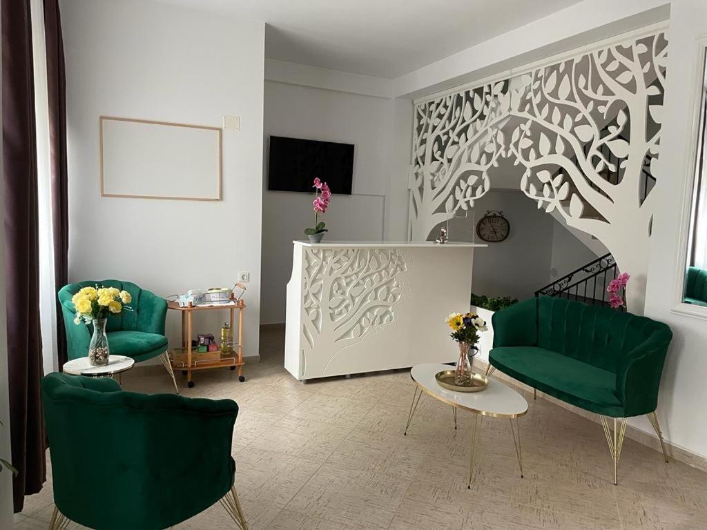 a living room with two green chairs and a table at Casa Eden Jupiter in Jupiter