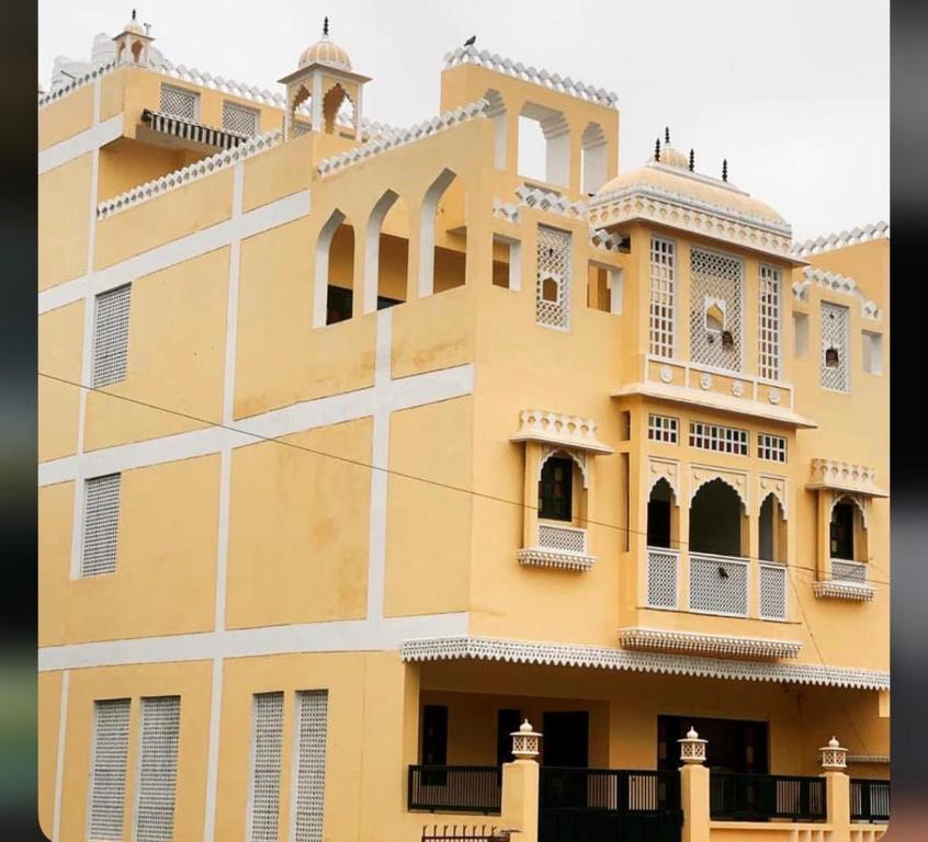 a large yellow building with windows and balconies at Shiv Kothi - Homestay in Agra