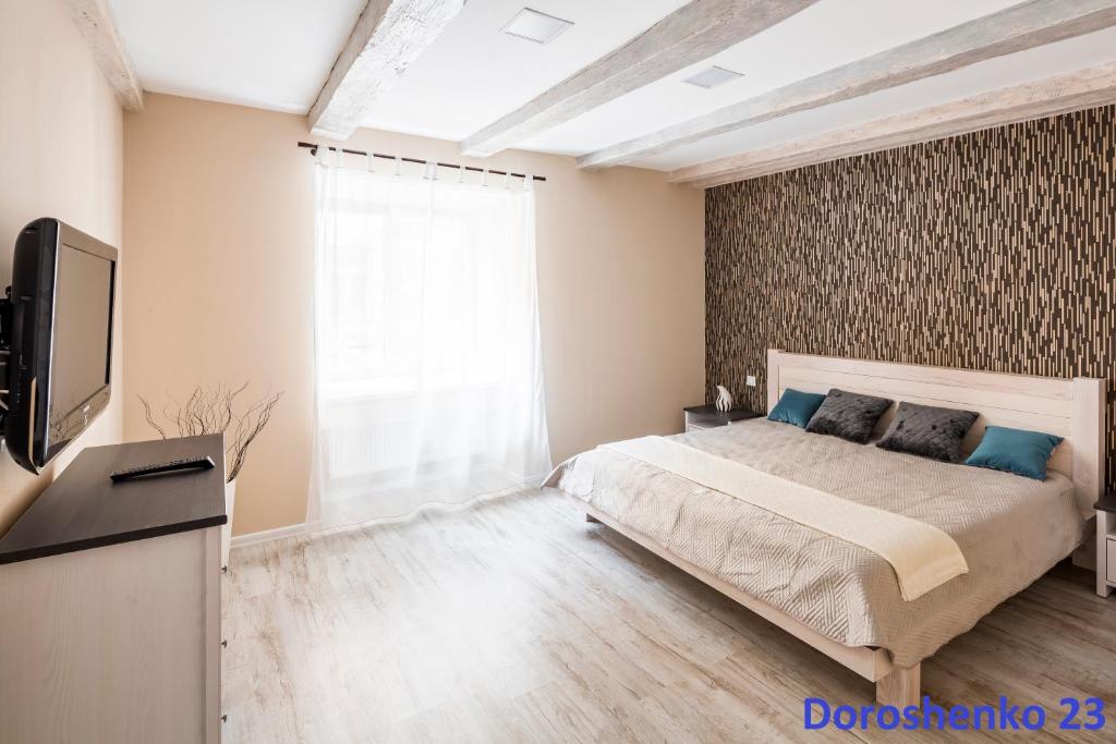 a bedroom with a bed and a television in it at Do Lvova Central Apartments in Lviv