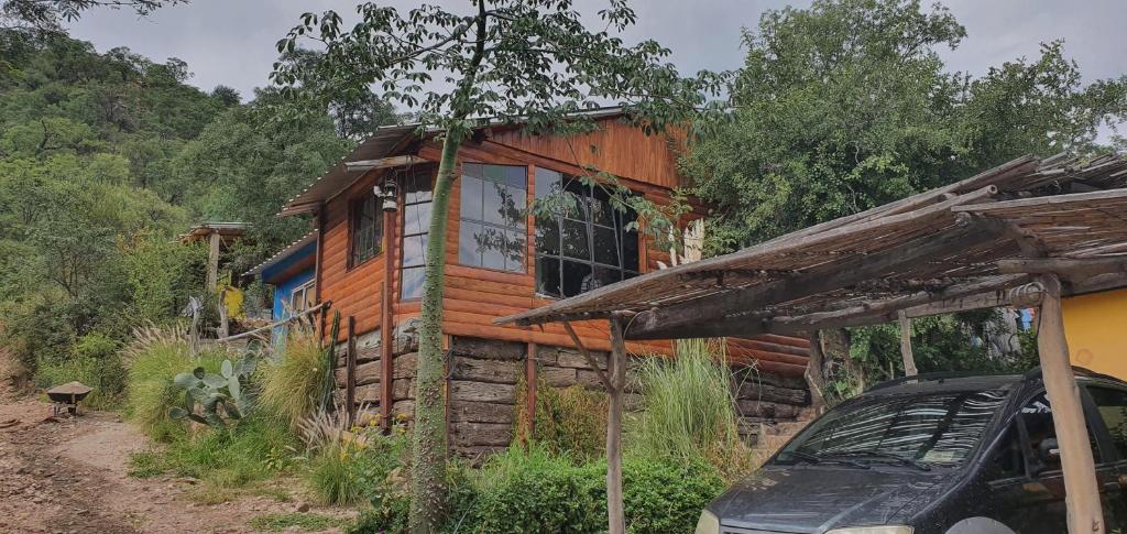 uma cabana com um carro estacionado em frente em AlfaCabañas em San Marcos Sierras