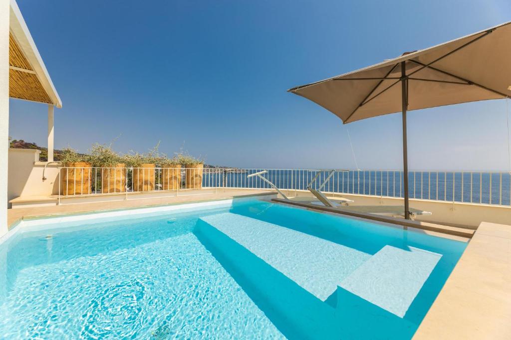 a swimming pool with an umbrella on top of a building at Marinaia Gran Vista Mare in Marittima