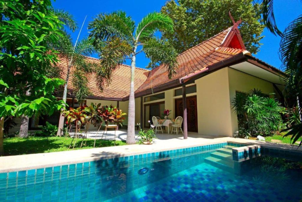 une maison avec une piscine en face d'une maison dans l'établissement Villa Raya Resort Private Pool Villas, à Pattaya (nord)