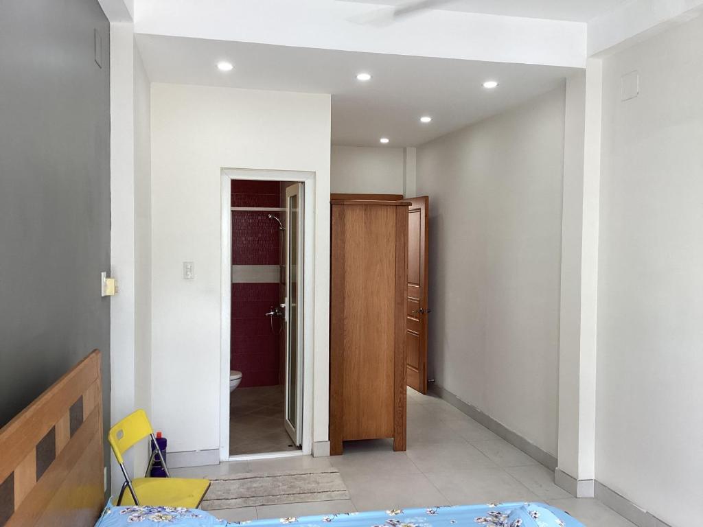 um quarto com uma cama e uma porta para uma casa de banho em KEIRA s HOUSE em Ho Chi Minh