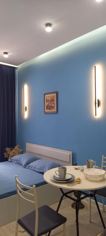 a blue room with a bed and a table at Aylin apartments 359/3 in Almaty