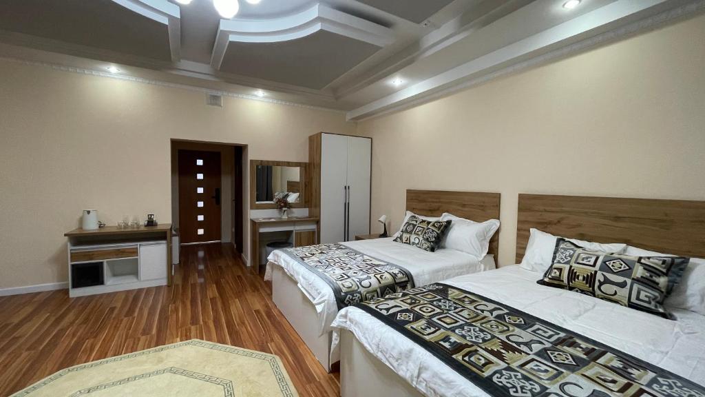 um quarto com duas camas e um lavatório. em “Simbad” guest house em Jalal-Abad