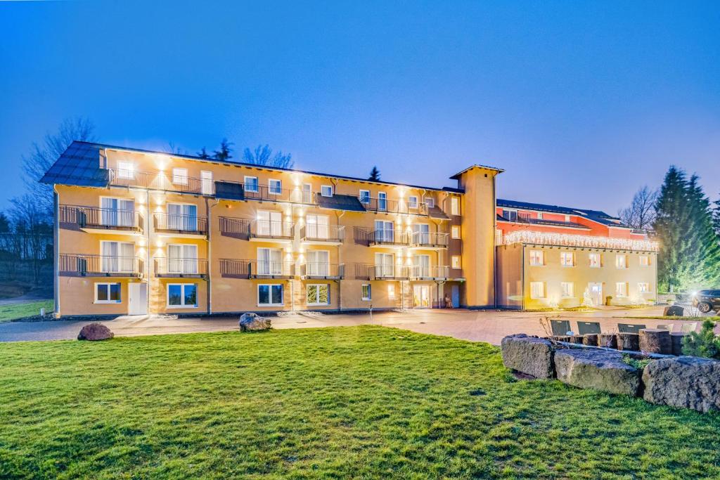 ein großes Gebäude mit Rasen davor in der Unterkunft Hotel & Pension Traumblick in Oberhof