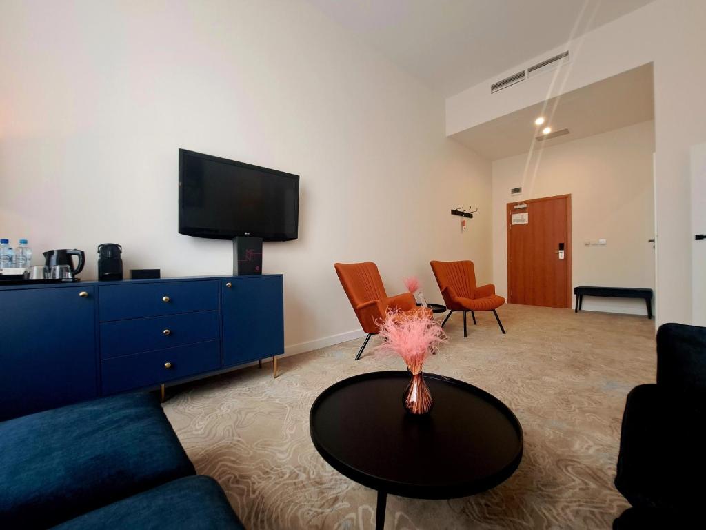 ein Wohnzimmer mit einem blauen Sofa und einem Tisch in der Unterkunft Focus Hotel Łódź in Łódź