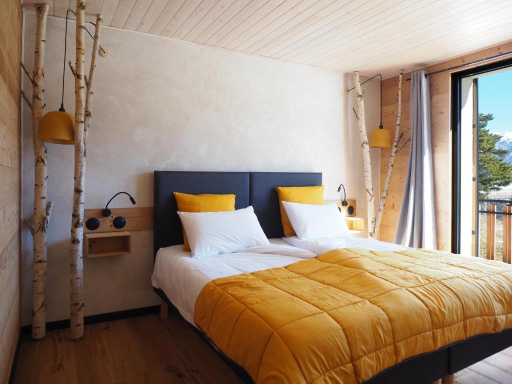 a bedroom with a bed with a yellow blanket at Gîte 170m2 6 à 8 personnes 4 chb 4 sdb vue montage au calme in Villard-de-Lans