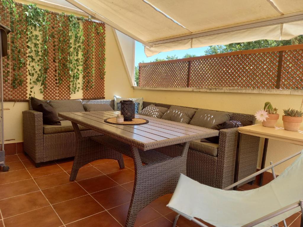 a patio with a table and chairs and a couch at Piso acogedor con terraza in Ciudad Real
