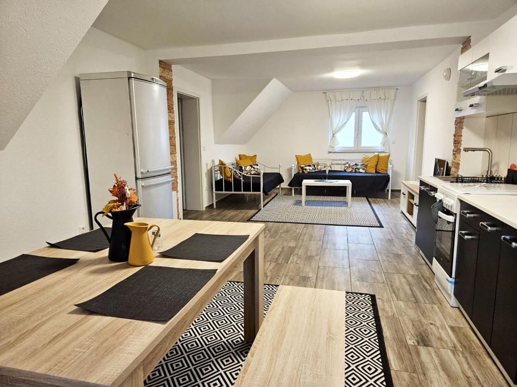 Work & Stay in Mannheim في مانهايم: مطبخ وغرفة معيشة مع طاولة في غرفة