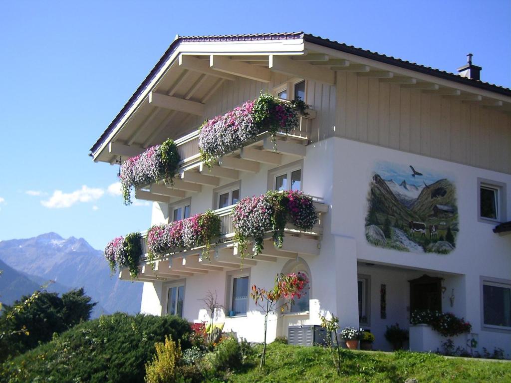 biały budynek z kwiatami na balkonach w obiekcie Ferienwohnung Zwoelferblick w mieście Bramberg am Wildkogel