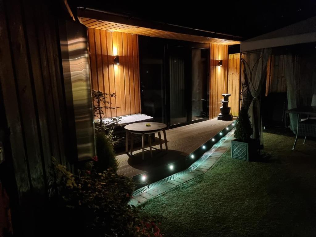 a patio at night with a table and lights at The Chill in Shepton Mallet