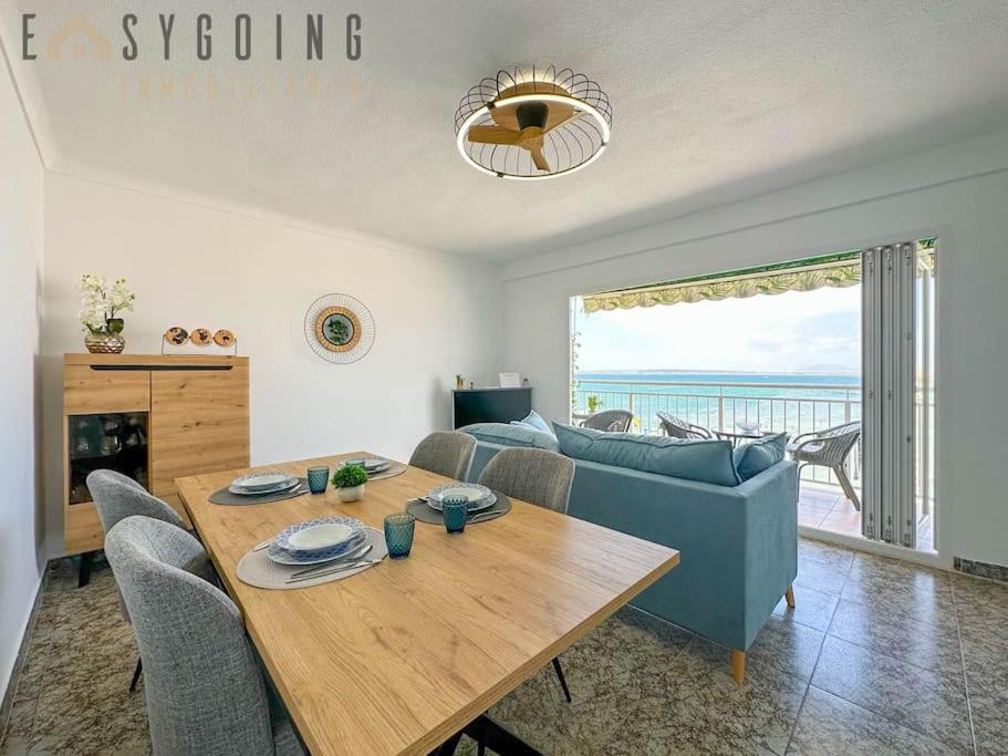 un soggiorno con tavolo e divano di Infinity Sea - Increíble piso con vistas al mar a Santa Pola