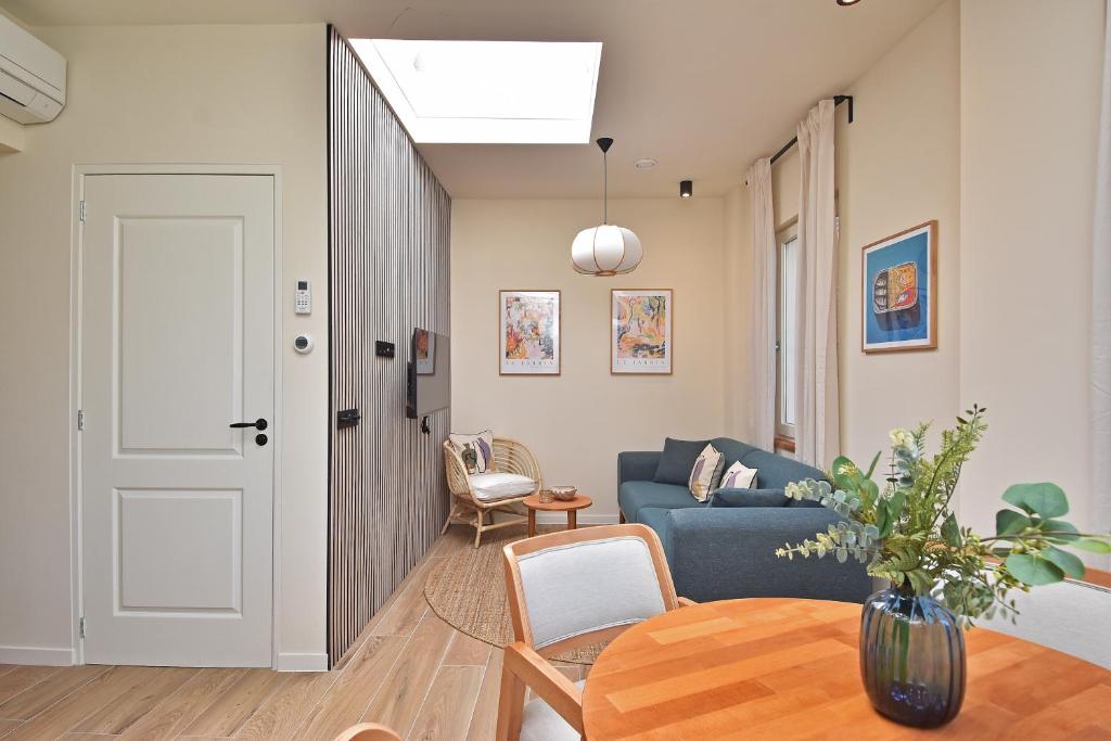 ein Wohnzimmer mit einem blauen Sofa und einem Tisch in der Unterkunft Four Star Apartments - Keizerstraat in Scheveningen